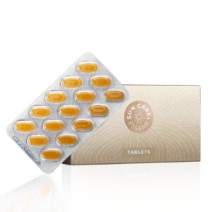 Essens Tanning Tablets and gold packaging on a black background.